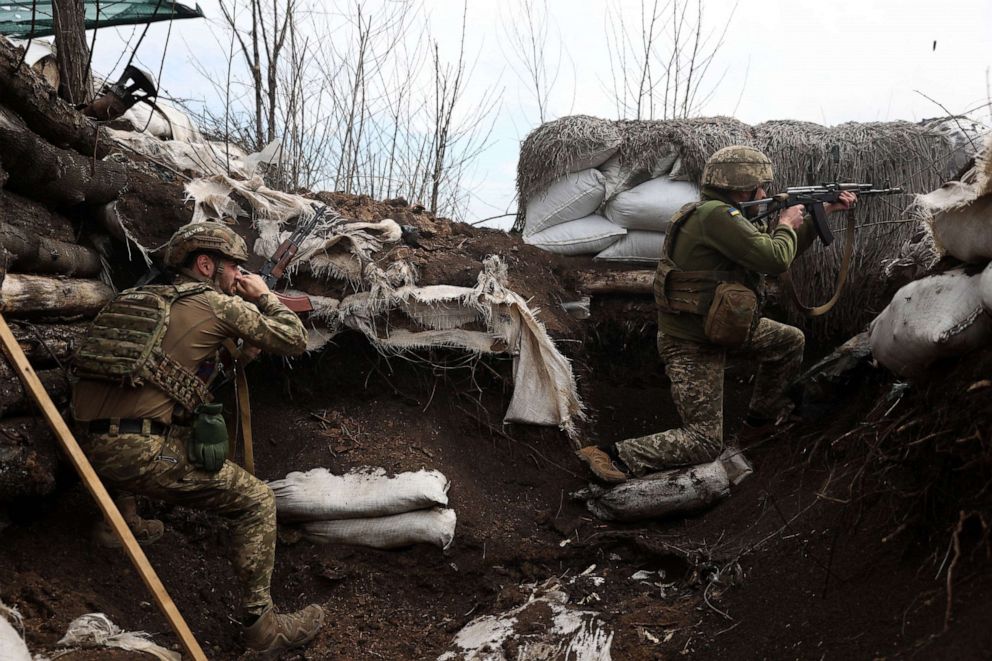 PHOTO: Ukrainian soldiers shoot with assault rifles in a trench on the front line with Russian troops in Lugansk region on April 11, 2022.