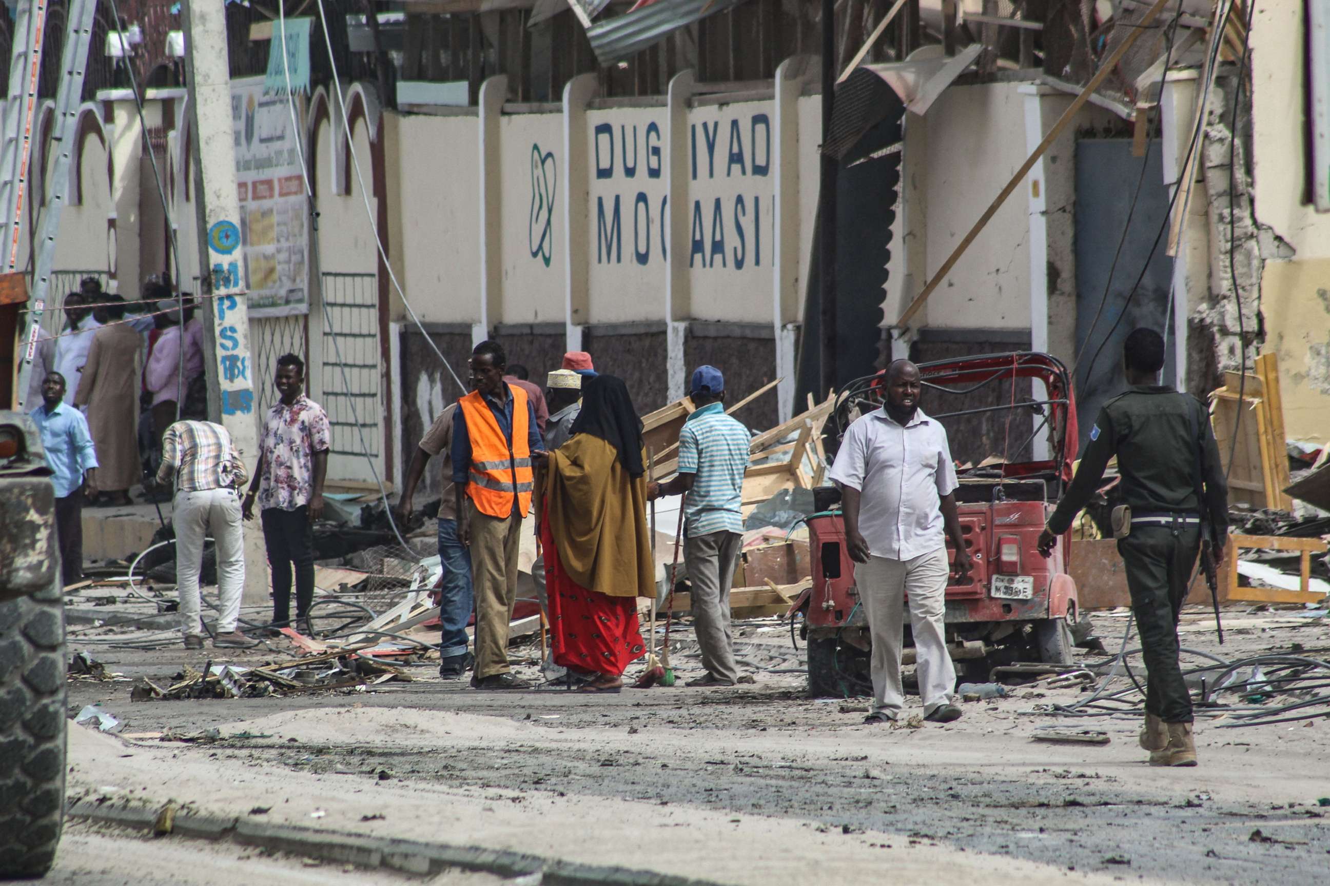 PHOTO: Police officers and people stand at the bomb explosion site in Mogadishu, Somalia, Nov. 25, 2021.