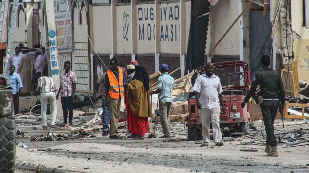 PHOTO: Police officers and people stand at the bomb explosion site in Mogadishu, Somalia, Nov. 25, 2021.