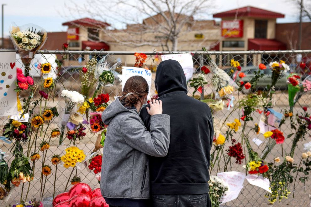 PHOTO: People comfort each other at a makeshift memorial outside a King Soopers grocery store, March 25, 2021, in Boulder, Colo.