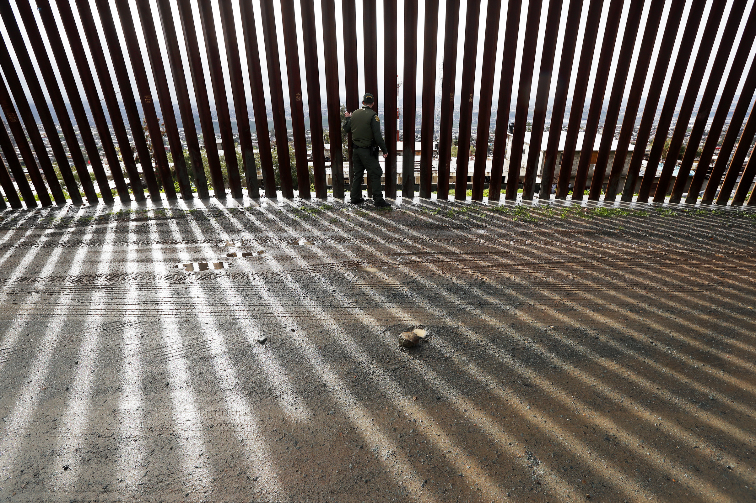PHOTO: Border Patrol agent Vincent Pirro touches a section of the border wall separating Tijuana, Mexico, behind, from San Diego, Feb. 5, 2019, in San Diego.