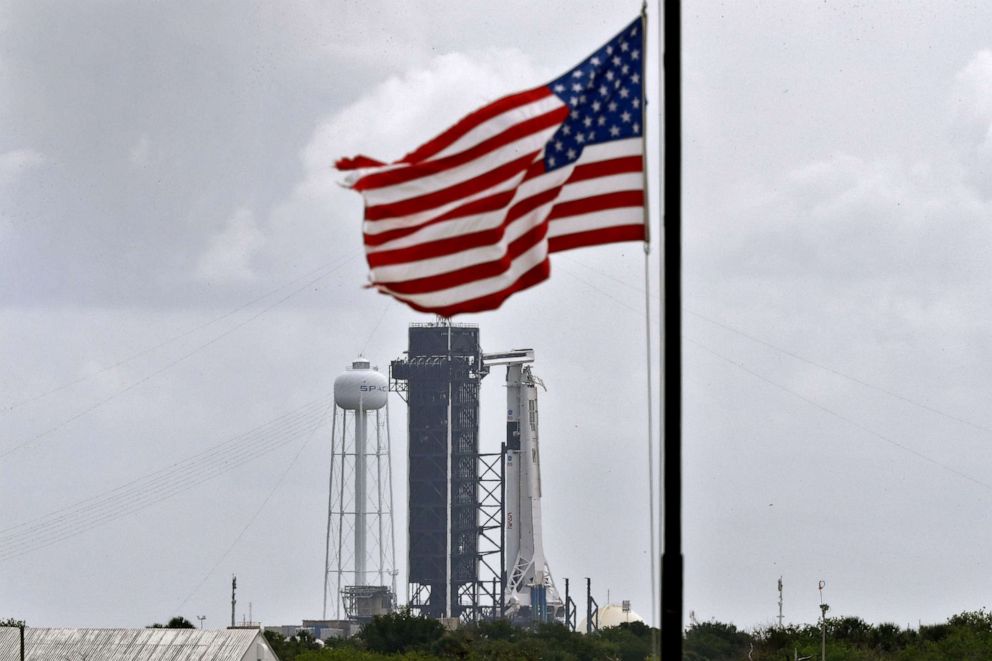 PHOTO: The SpaceX Falcon 9 with the Crew Dragon spacecraft on top of the rocket, sits on Launch Pad 39-A as the U.S flag flies at half staff, May 24, 2020, at Kennedy Space Center, in Fla. 