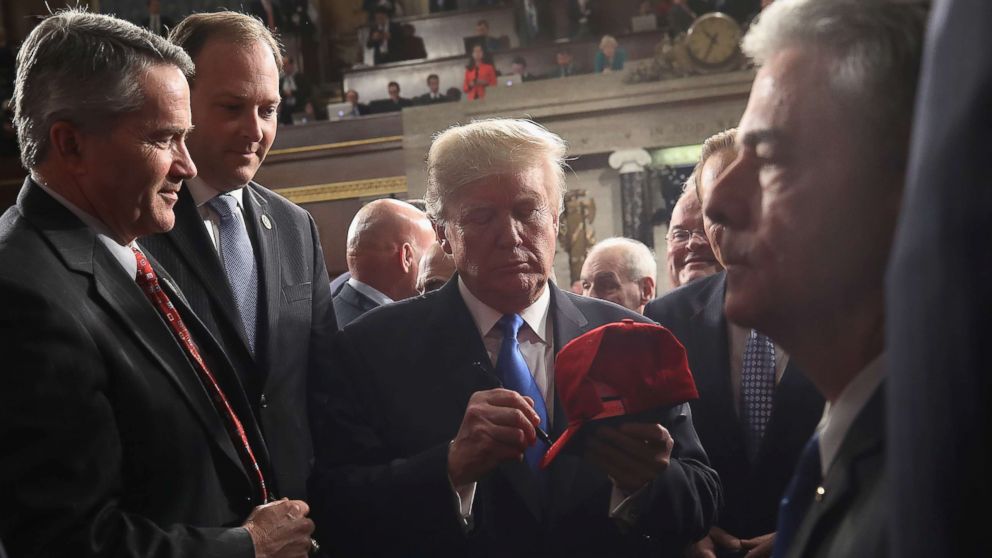 PHOTO: President Donald Trump signs a hat on his way out of the House chamber and after finishing his first State of the Union address, Jan. 30, 2018 in Washington, DC.