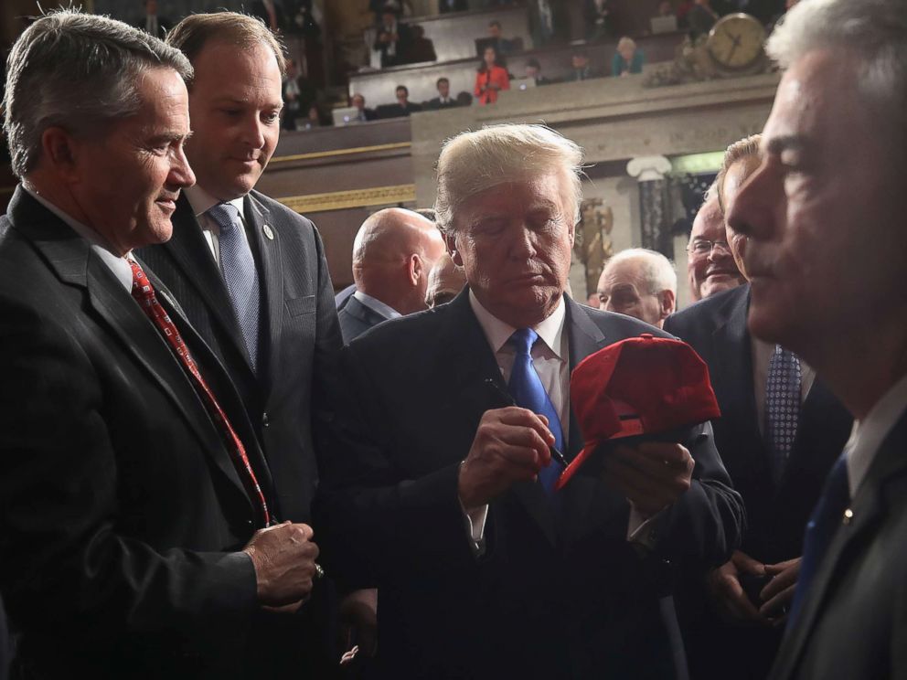 PHOTO: President Donald Trump signs a hat on his way out of the House chamber and after finishing his first State of the Union address, Jan. 30, 2018 in Washington, DC.
