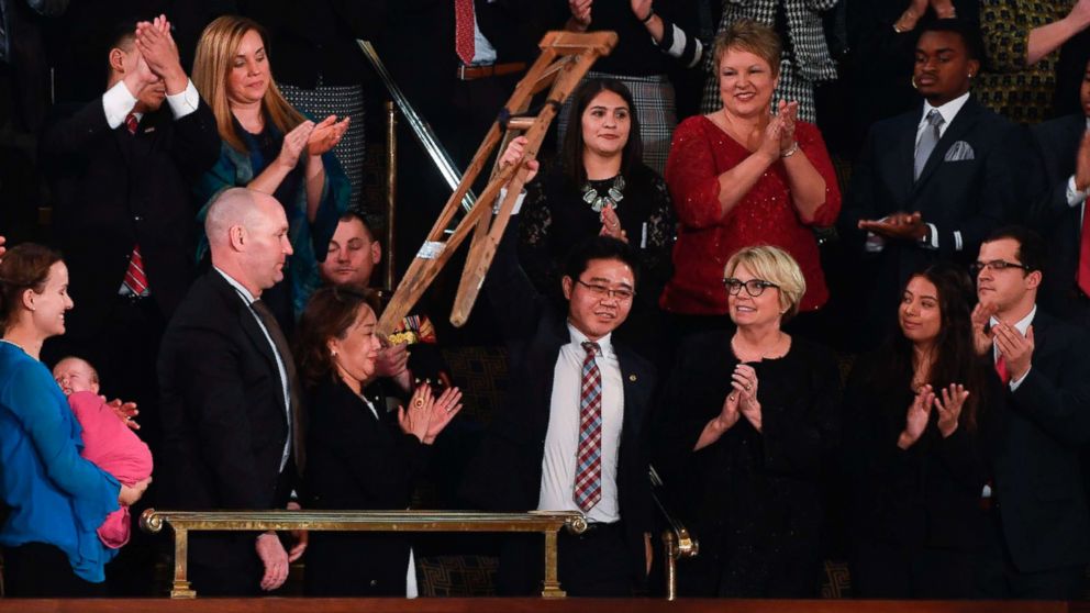 North Korean defector Ji Seong-ho raises his crutches as President Donald Trump delivers his State of the Union address at the US Capitol in Washington, on Jan. 30, 2018.