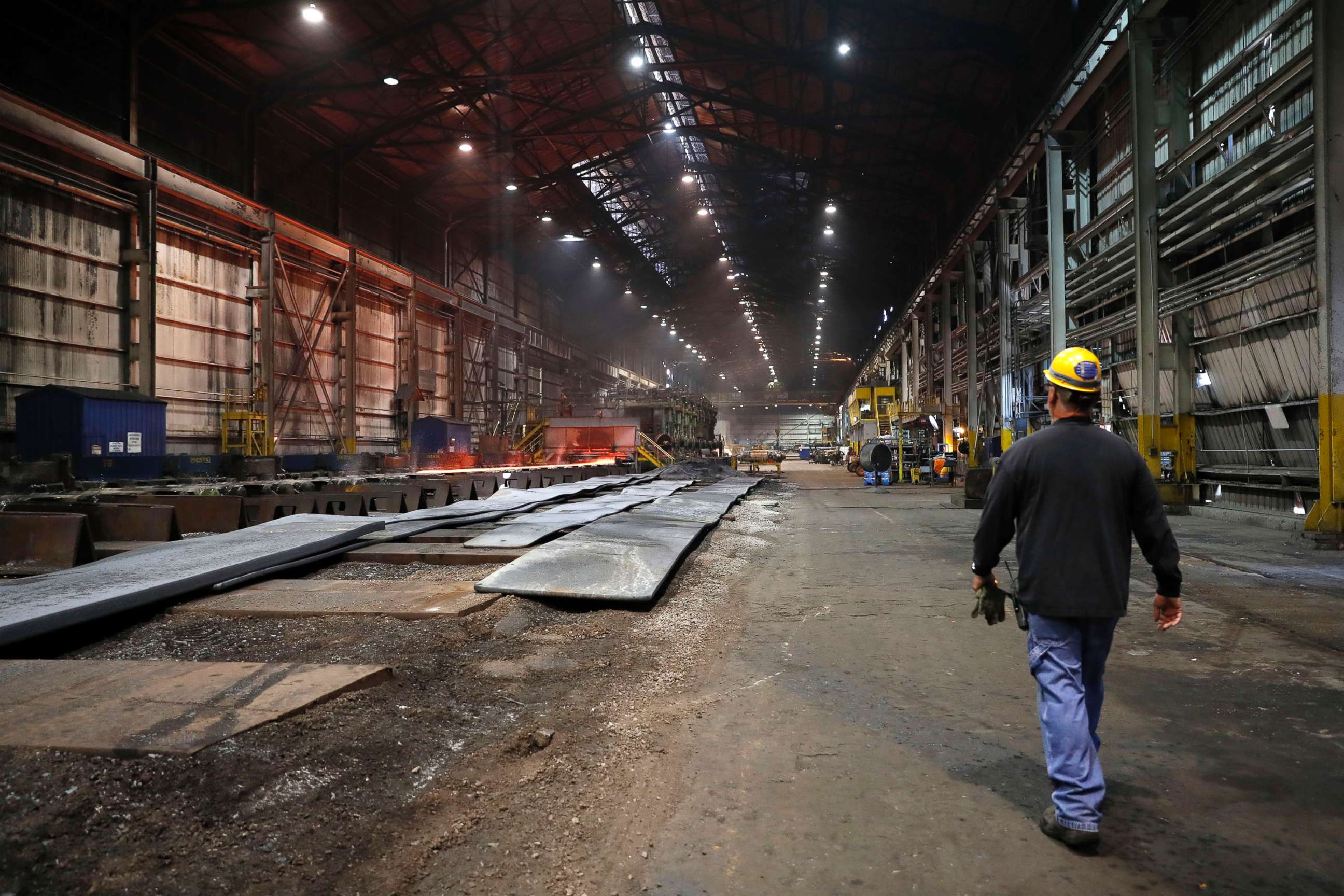 PHOTO: In this June 28, 2018, file photo, a worker walks inside the hot-strip mill at the U.S. Steel Granite City Works facility in Granite City, Ill.