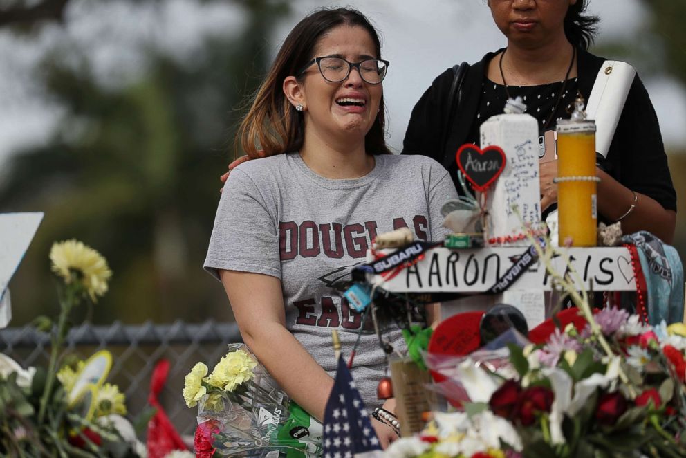 PHOTO: Ariana Gonzalez is over come with emotion as she visits a cross setup for her friend, football coach Aaron Feis, at the memorial in front of Marjory Stoneman Douglas High School, Feb. 23, 2018 in Parkland, Florida.