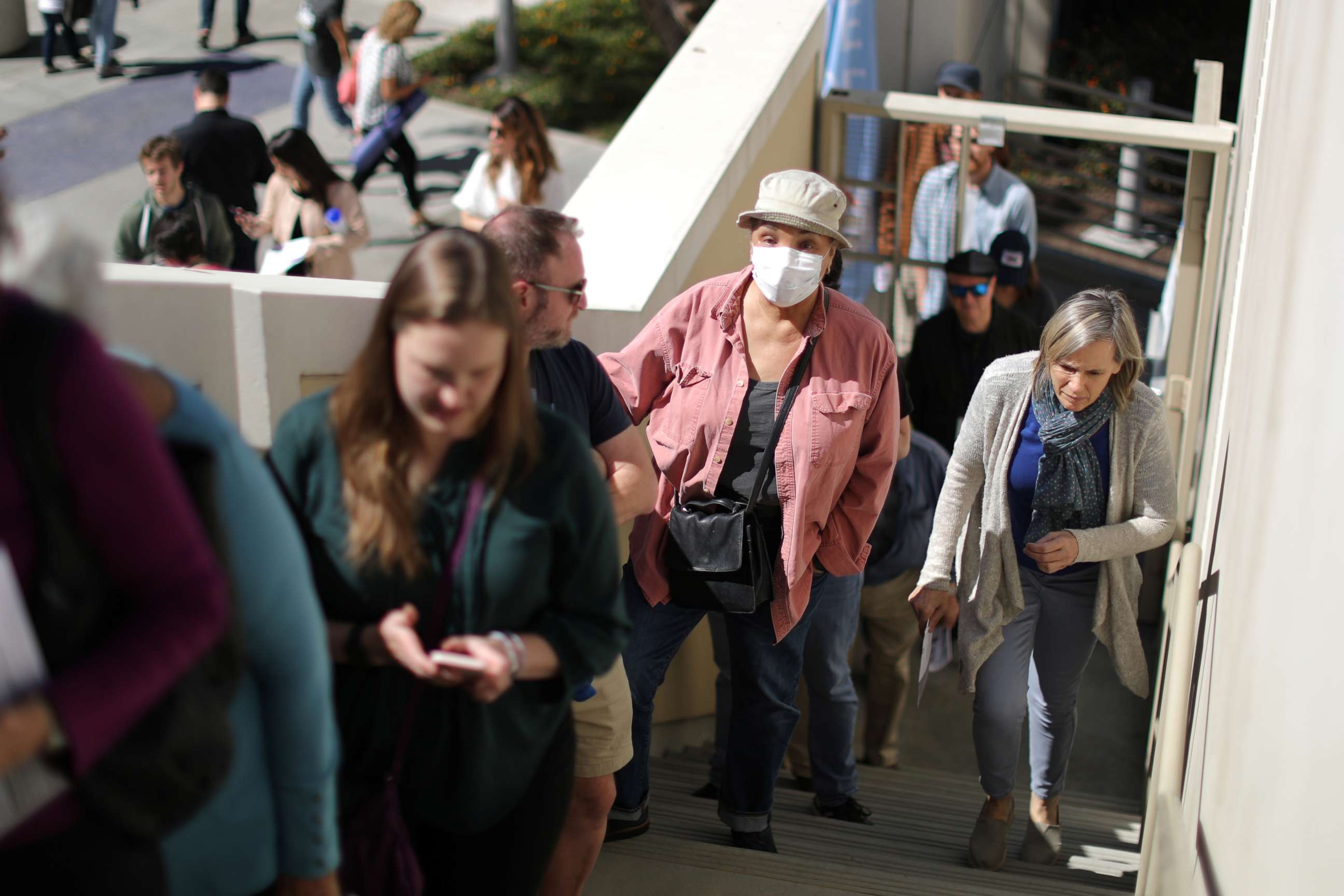 PHOTO: A woman wears a face mask as she lines up to vote at a polling station on Super Tuesday in Santa Monica, Calif., March 3, 2020.
