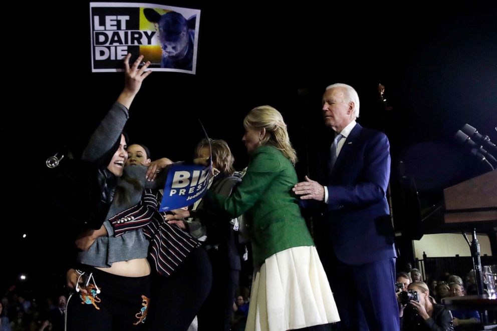PHOTO: A protester is held back by a Biden adviser and Jill Biden as Democratic presidential candidate former Vice President Joe Biden appears during a primary election night rally, March 3, 2020, in Los Angeles.