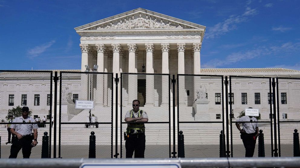 PHOTO: Capitol Police officers stand post behind the temporary anti-scaling fence surrounding the Supreme Court, June 28, 2022.