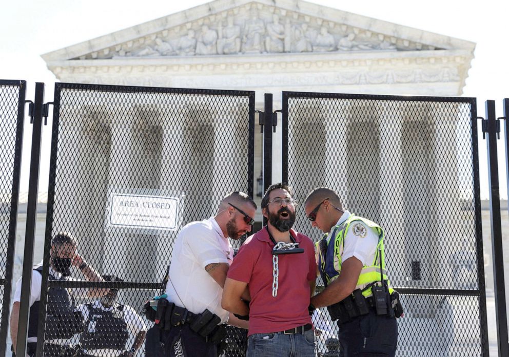 PHOTO: Police arrest abortion rights activist Guido Reichstadter of Miami after he chained himself to security fencing while protesting against the court's expected decision overturning the Roe v Wade ruling outside the Supreme Court, June 6, 2022.