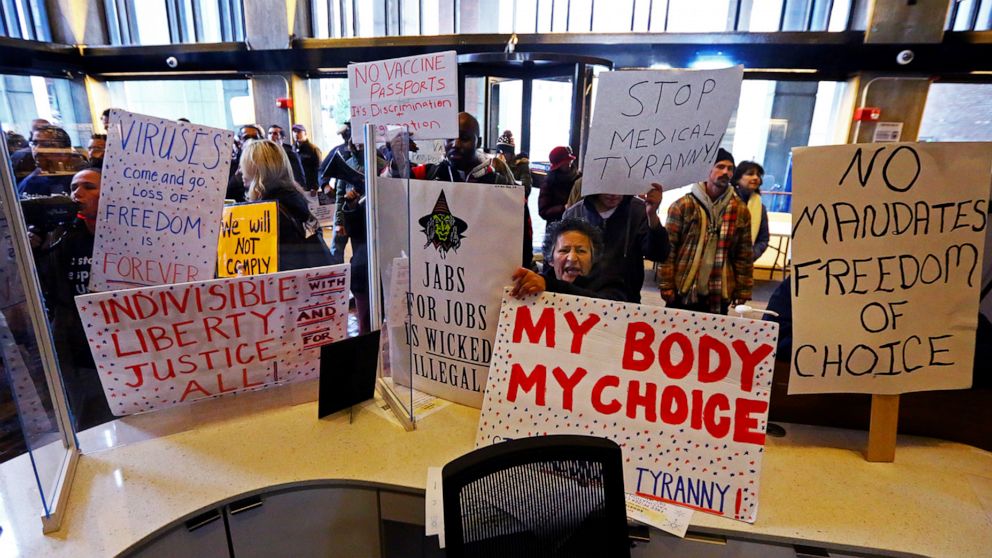 PHOTO: Protesters hold signs reading my body my choice, stop medical tyranny, and more, at City Hall in Boston, Dec. 20, 2021.