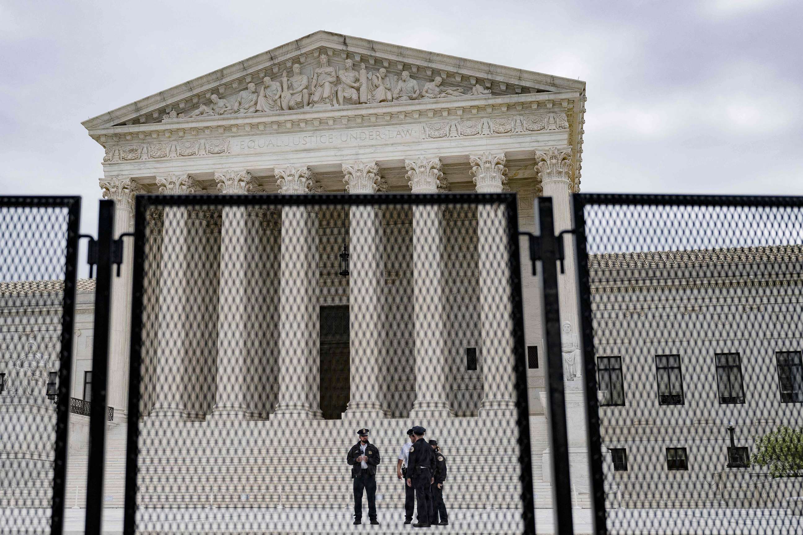 PHOTO: Police officers patrol near an un-scalable fence that stands around the U.S. Supreme Court in Washington, D.C., on May 5, 2022. The fencing is being set up due to the protests in response to the leaked draft of a majority opinion on abortion.