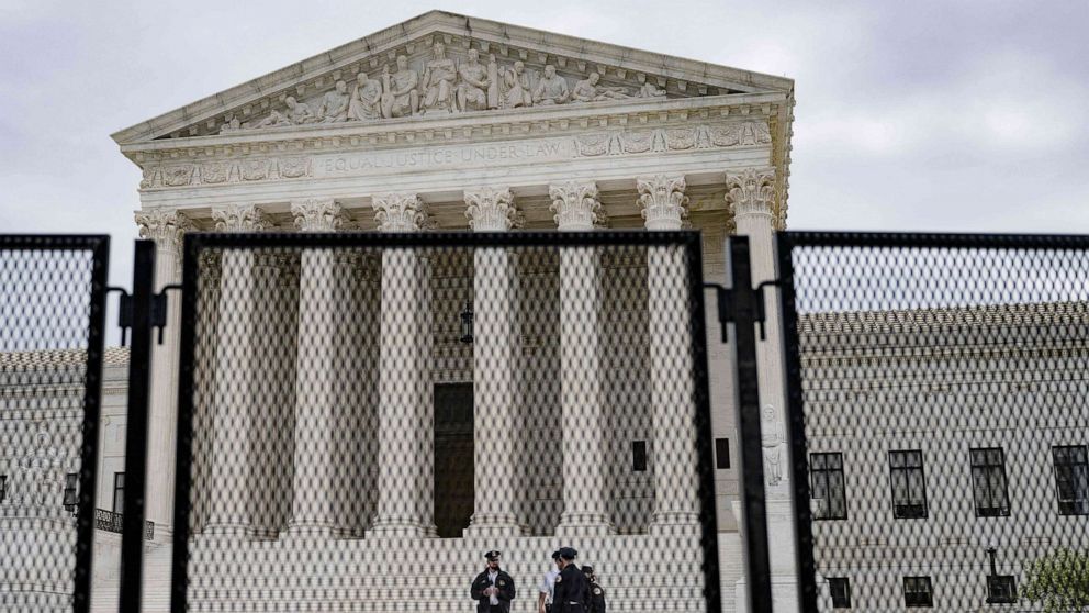 PHOTO: Police officers patrol near an un-scalable fence that stands around the U.S. Supreme Court in Washington, D.C., on May 5, 2022. The fencing is being set up due to the protests in response to the leaked draft of a majority opinion on abortion.