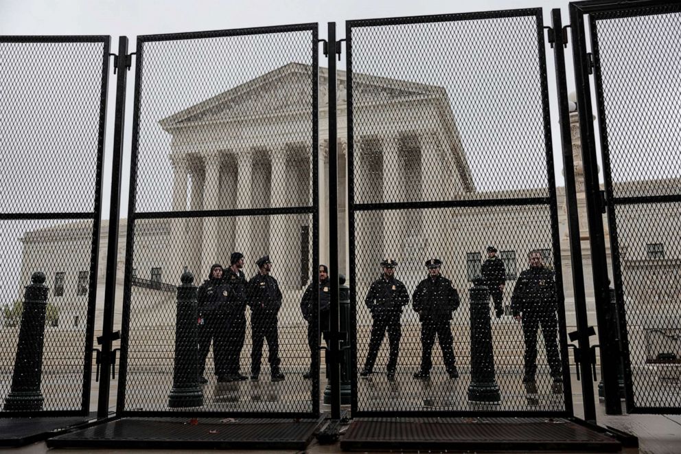 PHOTO: Supreme Court Police Officers stand watch behind a fence surrounding the Supreme Court Building on May 7, 2022 in Washington, D.C.