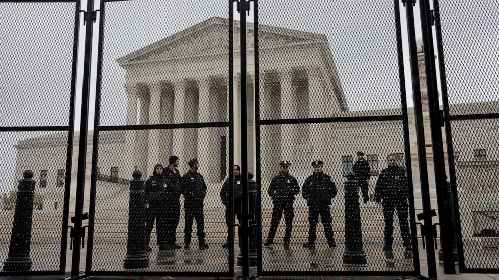 PHOTO: Supreme Court Police Officers stand watch behind a fence surrounding the Supreme Court Building on May 7, 2022 in Washington, D.C.