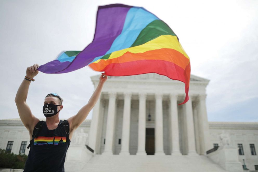 PHOTO: Joseph Fons holding a Pride Flag, stands in front of the U.S. Supreme Court building after the court ruled that LGBTQ people can not be disciplined or fired based on their sexual orientation, June 15, 2020 in Washington, DC.