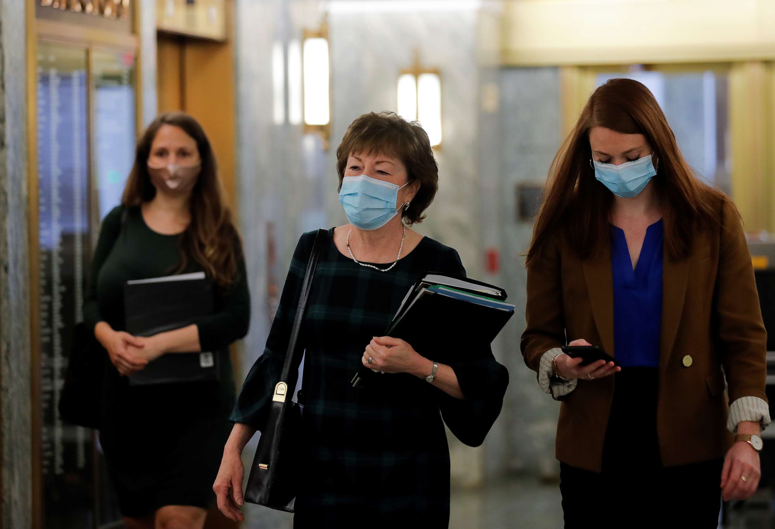PHOTO: Senator Susan Collins and members of her staff wear protective face masks as they arrive prior to a Senate Health Education Labor and Pensions Committee hearing on Capitol Hill in Washington, May 12, 2020.