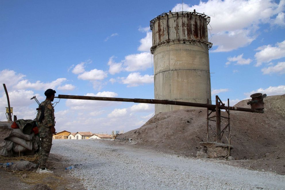 PHOTO: A fighter with local armed forces allied with the Kurdish administration stands guard at a military base from which U.S. forces pulled out, in the town of Tel Arqam in Syria on Oct. 6, 2019.