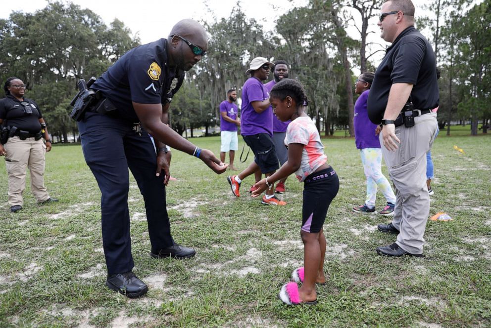 PHOTO: Tampa Police Officer Phil Douillard participates in an egg tossing game with kids from the Teen Summit organization at Rowlett Park, on June 26, 2021, in Tampa.