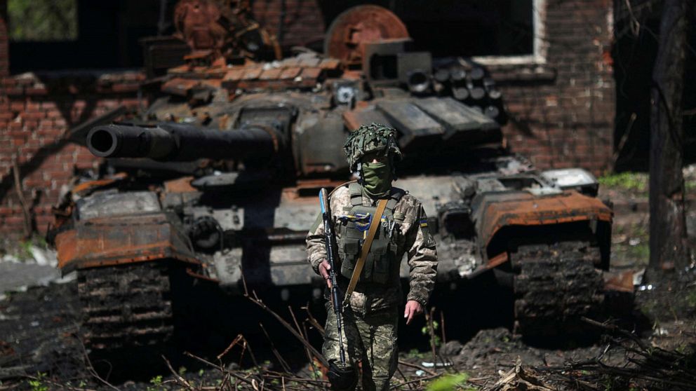 PHOTO: A Ukrainian soldier poses next to a destroyed Russian tank in Malaya Rohan village, amid Russia's attack on Ukraine, near Kharkiv, Ukraine, May 5, 2022. 