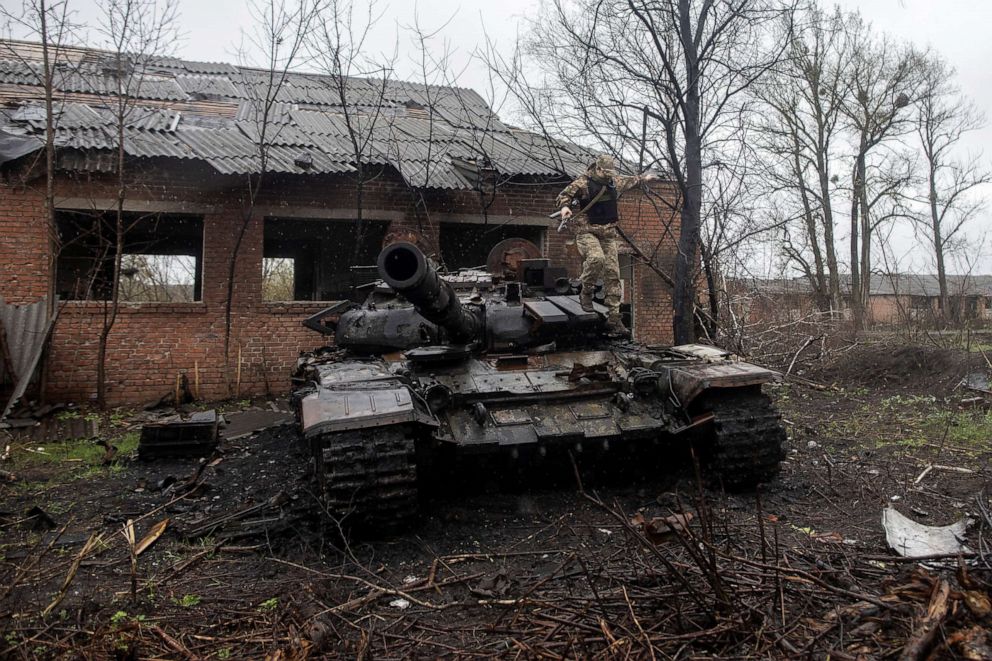 PHOTO: A Ukrainian soldier jumps of a destroyed Russian tank on the outskirts of the village of Mala Rohan, amid Russia's invasion of Ukraine, in Kharkiv region, Ukraine, April 20, 2022. 