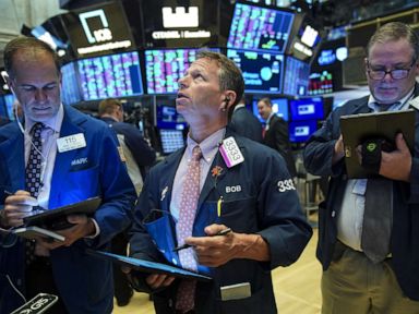 PHOTO: Traders and financial professionals work on the floor of the New York Stock Exchange (NYSE) at the opening bell on August 13, 2019, in New York.