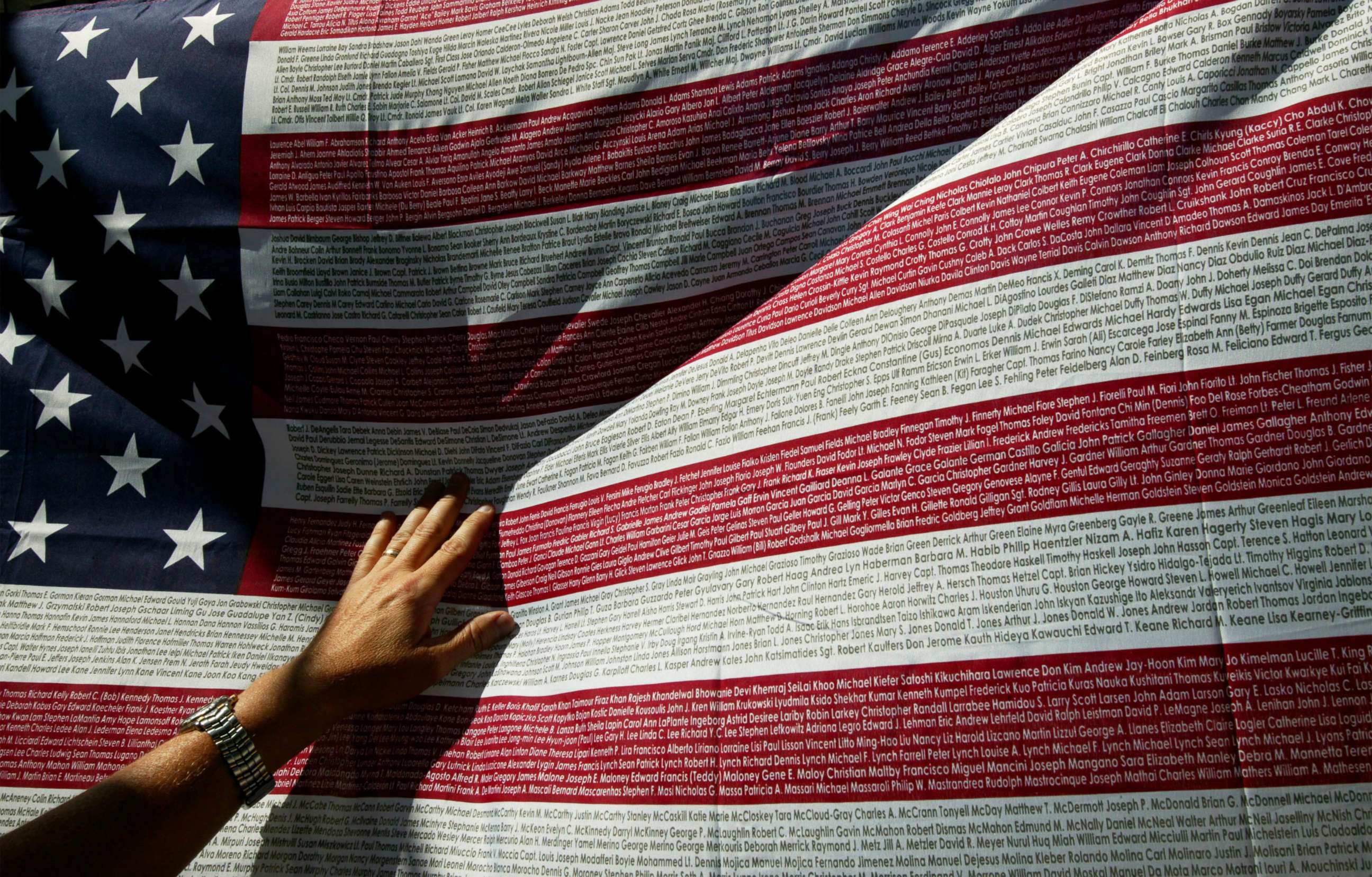 PHOTO: A relative of a victim of the Sept. 11th terrorist attacks looks for a name on a flag with names of the victims at the World Trade Center site, Sept. 10, 2003, in New York.
