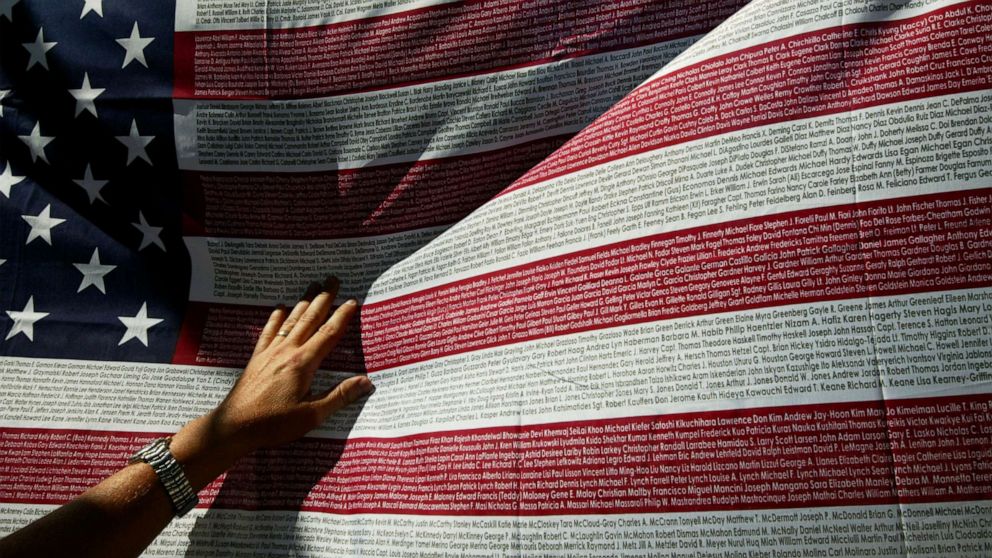 PHOTO: A relative of a victim of the Sept. 11th terrorist attacks looks for a name on a flag with names of the victims at the World Trade Center site, Sept. 10, 2003, in New York.