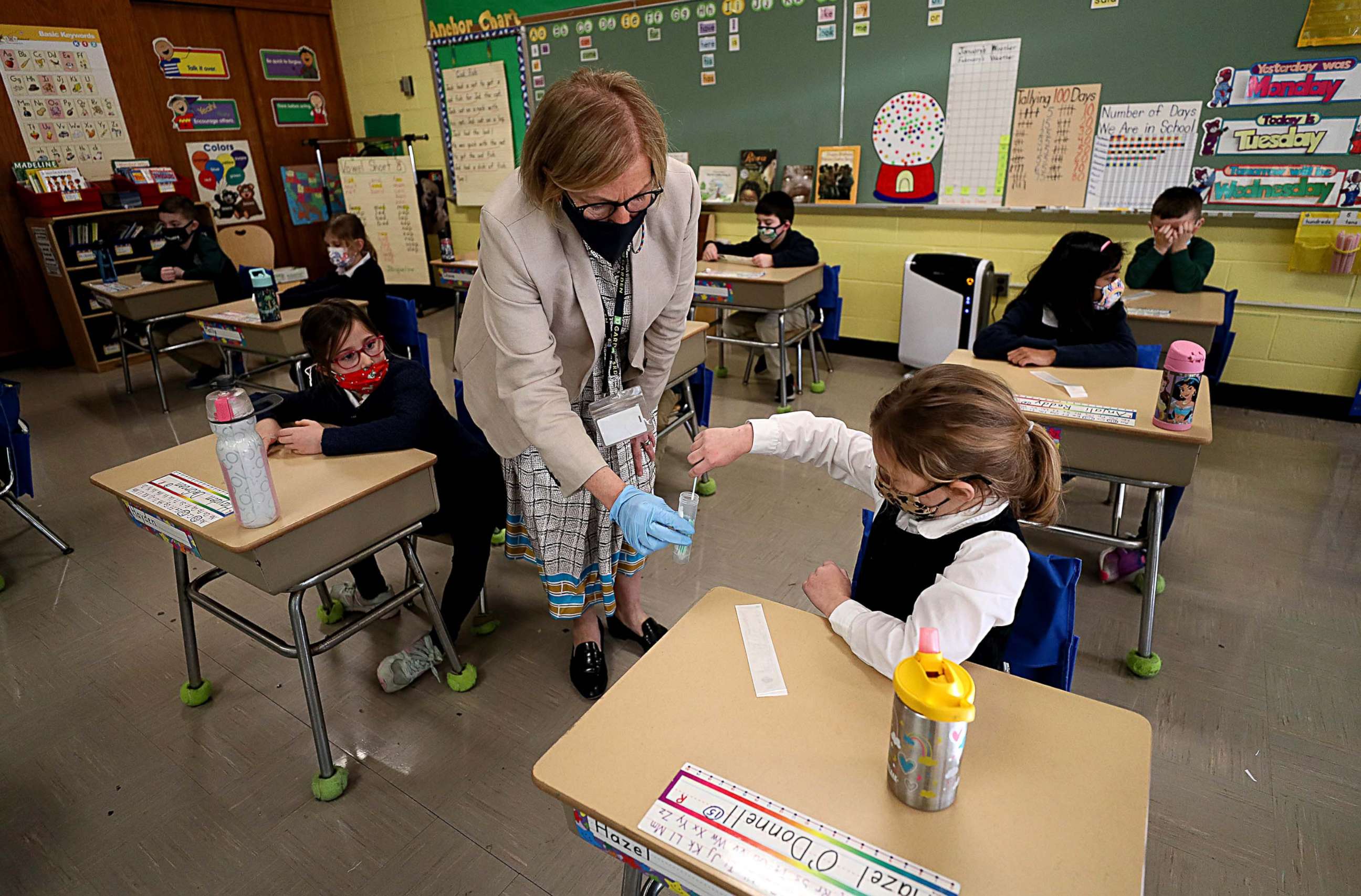 PHOTO: A student gives her COVID-19 swab to Dr. Helenann Civian, the principal of South Boston Catholic Academy in Boston, Jan. 19, 2021.