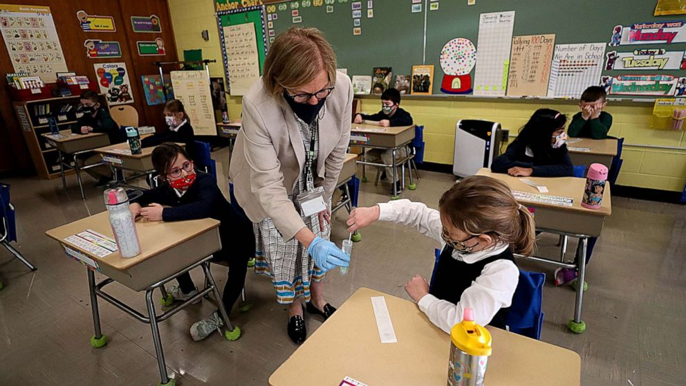 PHOTO: A student gives her COVID-19 swab to Dr. Helenann Civian, the principal of South Boston Catholic Academy in Boston, Jan. 19, 2021.