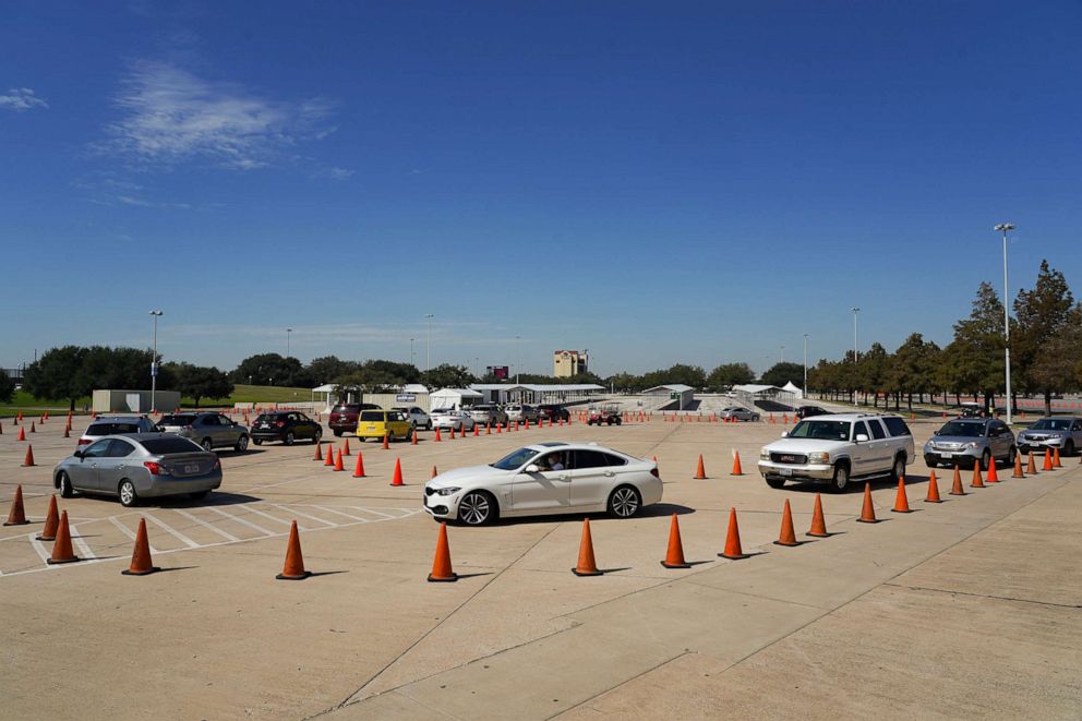PHOTO: Voters in cars line up at a drive-through mail ballot drop-off site at NRG Stadium on Oct. 7, 2020 in Houston.