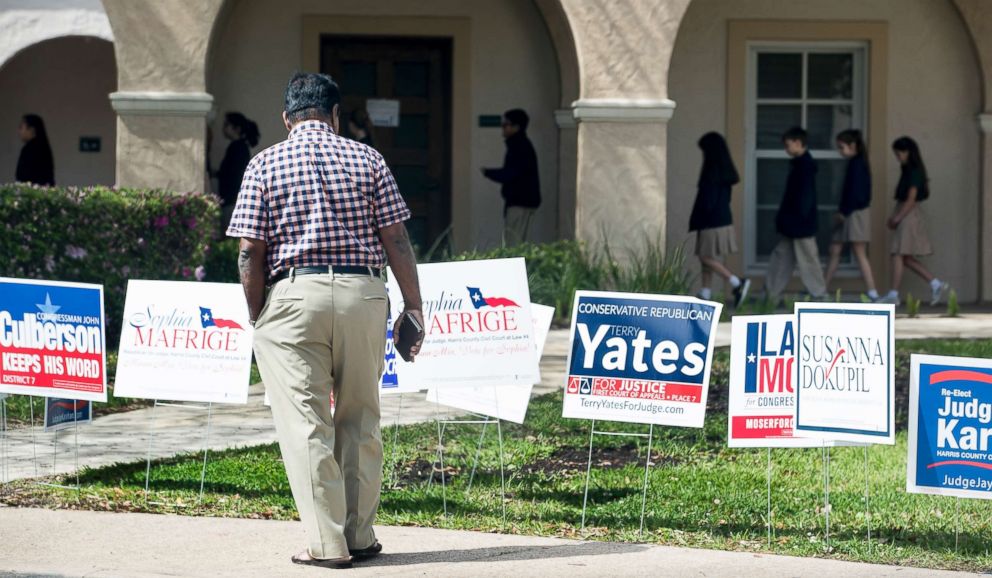 PHOTO: A voter stops to look at primary election signs outside the polling place at St. Anne's Catholic Church on Tuesday, March 6, 2018, in Houston.