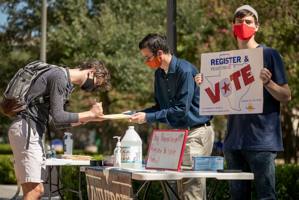 PHOTO: Deputy voter registrars help Jonathan Geymer, 19, left, register to vote at a voter registration drive on the University of Texas campus in Austin, Oct. 5, 2020.