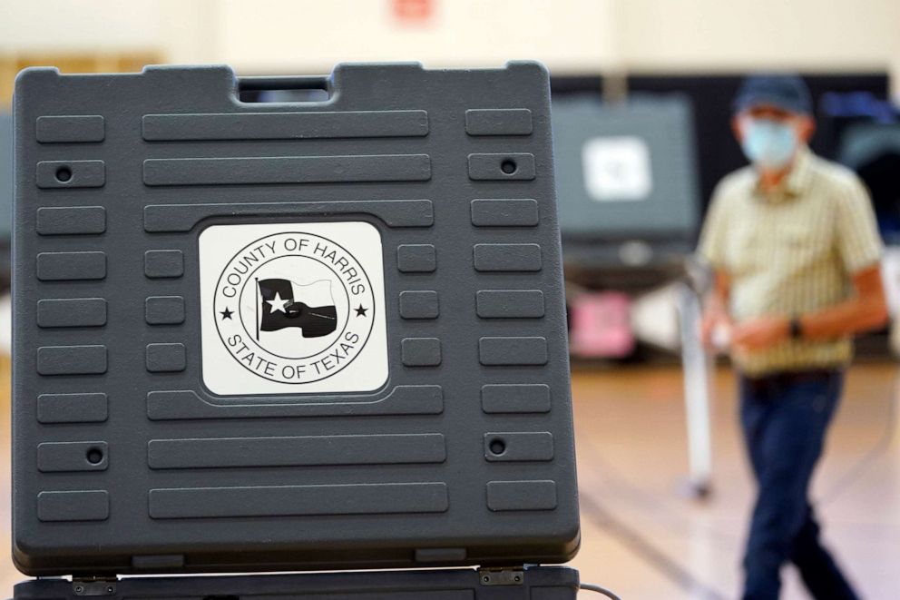 PHOTO: A voter passes by a voting booth after voting, July 14, 2020, in Houston.