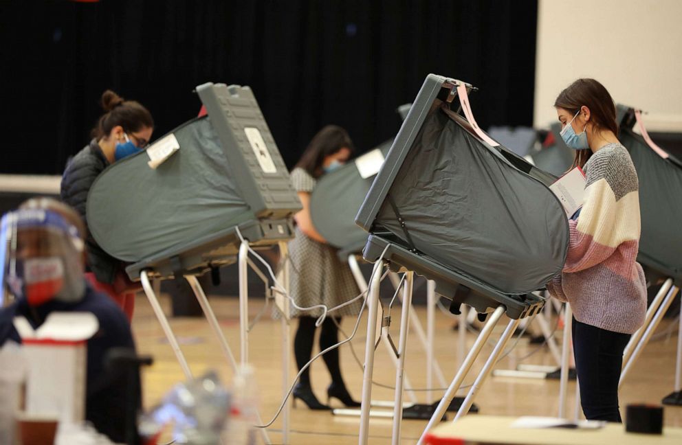 PHOTO: In this Nov. 3, 2020, file photo, voters wearing protective masks cast ballots at a polling location for the 2020 Presidential election in Houston.