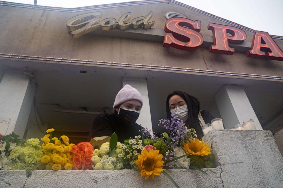 PHOTO:  Mourners visit and leave flowers at the site of two shootings at spas across the street from one another in Atlanta, March 17, 2021. 