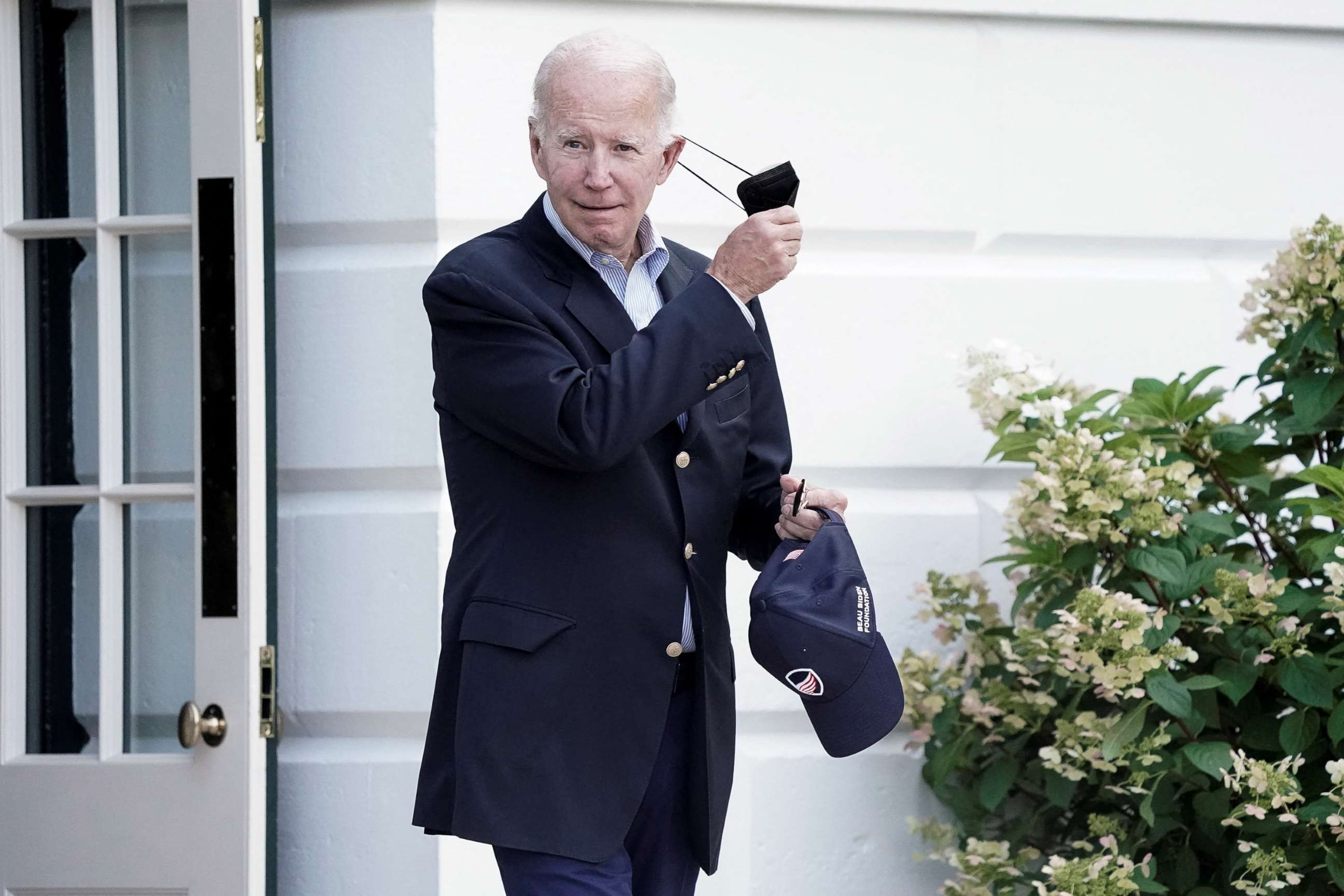 PHOTO: President Joe Biden takes off his mask as he walks towards Marine One for departure to Rehoboth Beach, Del., Aug. 7, 2022.