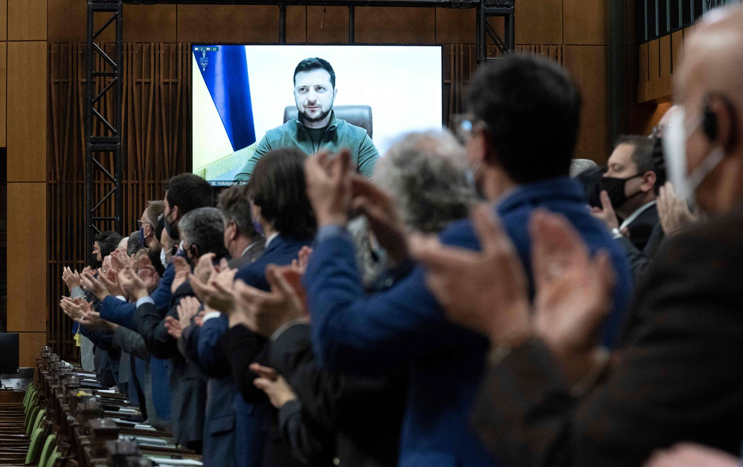 PHOTO: Ukrainian President Volodymyr Zelenskyy is applauded by Canadian members of Parliament while delivering a virtual address in Ottawa, March 15, 2022.