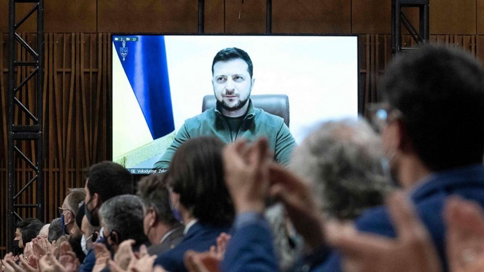 PHOTO: Ukrainian President Volodymyr Zelenskyy is applauded by Canadian members of Parliament while delivering a virtual address in Ottawa, March 15, 2022.