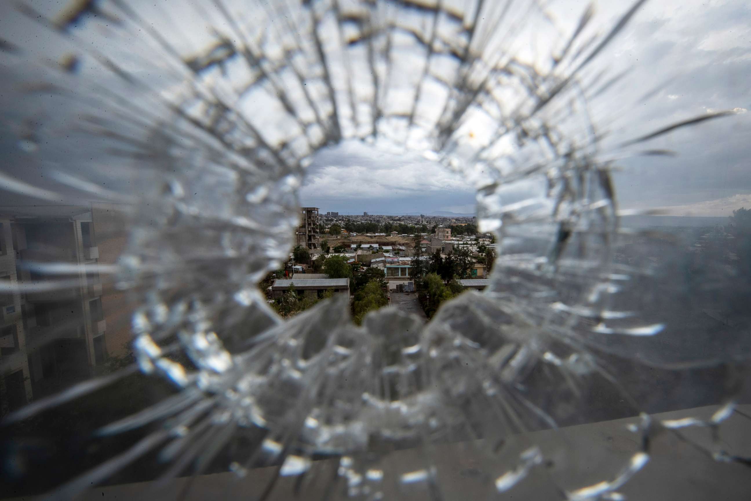 PHOTO: The city of Mekele is seen through a bullet hole in a stairway window of the Ayder Referral Hospital in the Tigray region of northern Ethiopia on May 6, 2021.