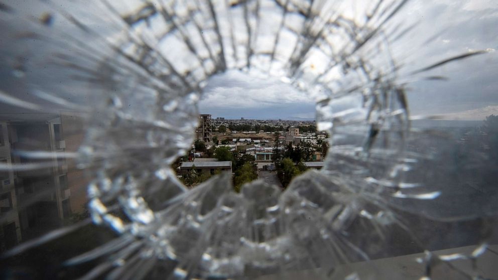 PHOTO: The city of Mekele is seen through a bullet hole in a stairway window of the Ayder Referral Hospital in the Tigray region of northern Ethiopia on May 6, 2021.