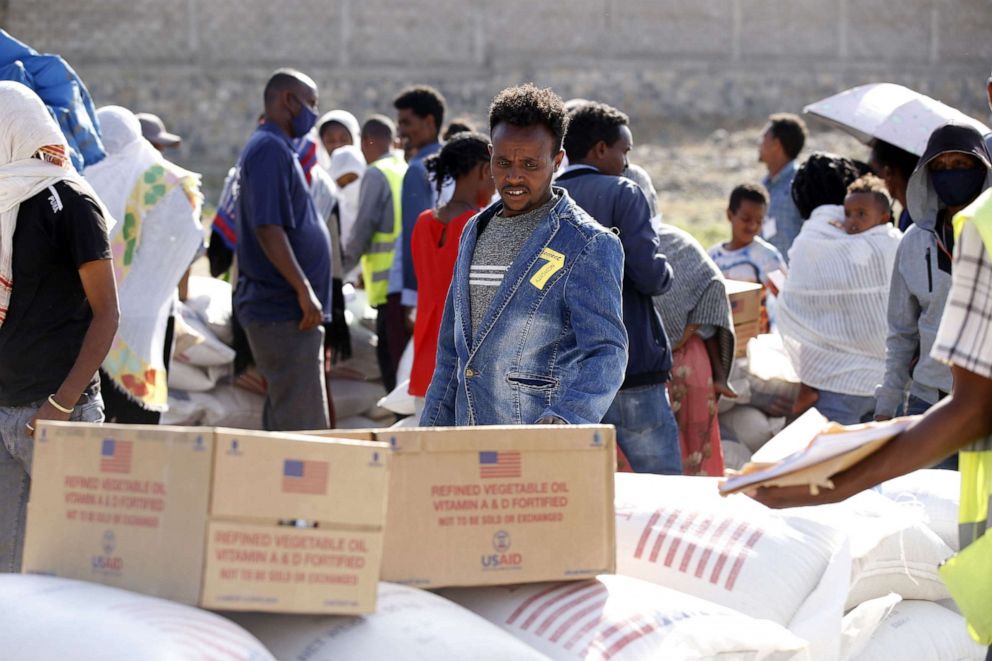 PHOTO: Tigray people, fled due to conflicts and taking shelter in Mekelle city of the Tigray region, in northern Ethiopia, receive the food aid distributed by United States Agency for International Development (USAID) on March 8, 2021.
