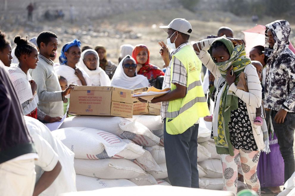 PHOTO: Tigray people, fled due to conflicts and taking shelter in Mekelle city of the Tigray region, in northern Ethiopia, receive the food aid distributed by United States Agency for International Development (USAID) on March 8, 2021.