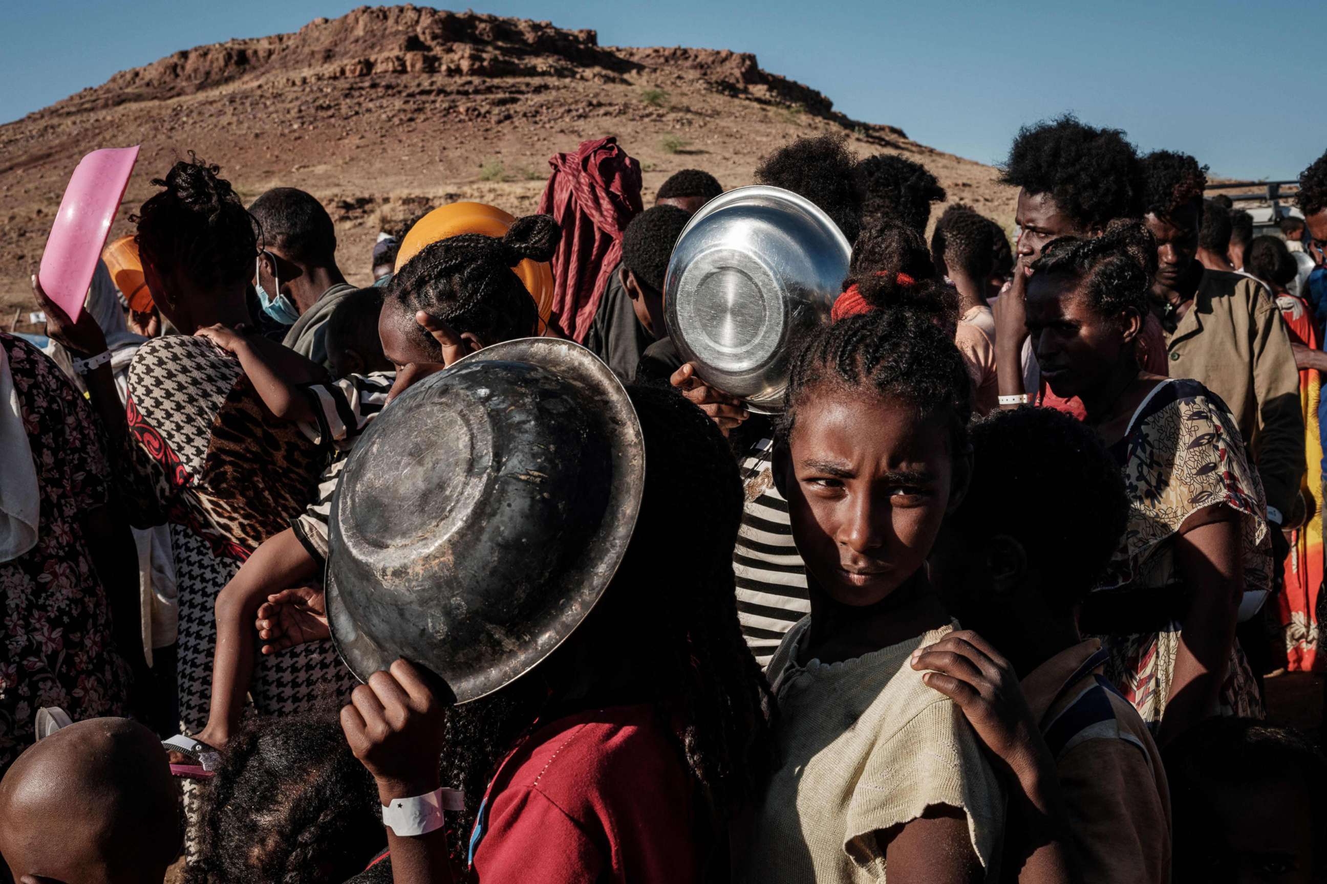 PHOTO: Refugee children, who fled the Ethiopia's Tigray conflict, wait in a line for a food distribution by Muslim Aid at the Um Raquba refugee camp in Sudan's eastern Gedaref state, Dec. 12, 2020.