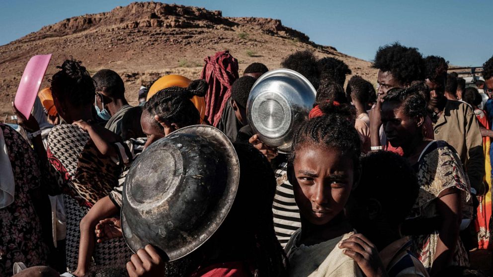 PHOTO: Refugee children, who fled the Ethiopia's Tigray conflict, wait in a line for a food distribution by Muslim Aid at the Um Raquba refugee camp in Sudan's eastern Gedaref state, Dec. 12, 2020.