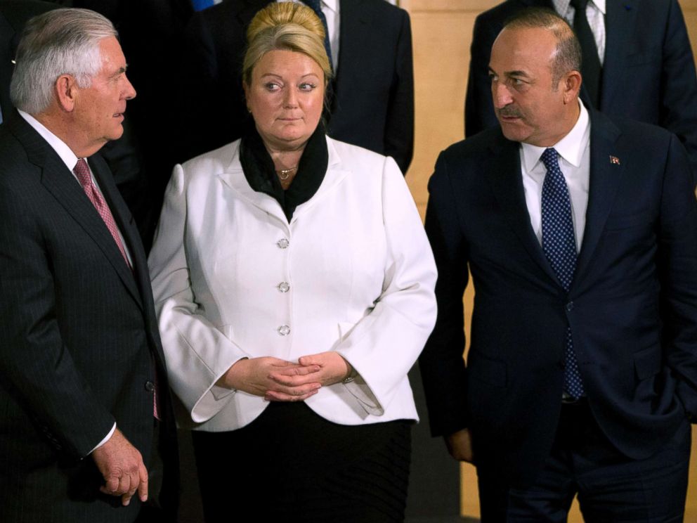 PHOTO: Secretary of State Rex Tillerson, left, speaks with Turkish Foreign Minister Mevlut Cavusoglu, right, during a group photo of NATO foreign ministers in Brussels, Dec. 5, 2017. British Permanent Representative to NATO Sarah MacIntosh is at center.