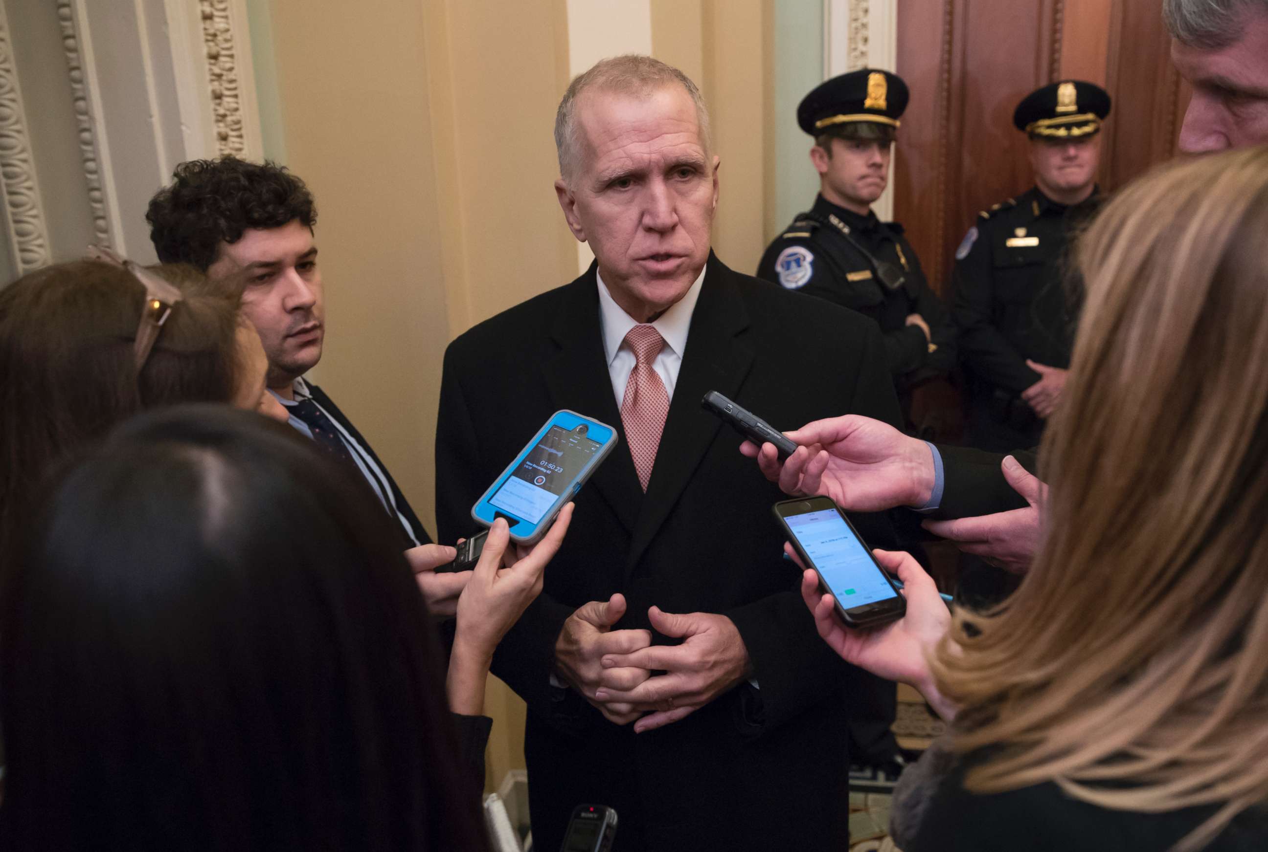PHOTO: Sen. Thom Tillis, R-N.C., is surrounded by reporters as he makes his way to a closed-door GOP policy luncheon, at the Capitol, Jan. 4, 2018. 