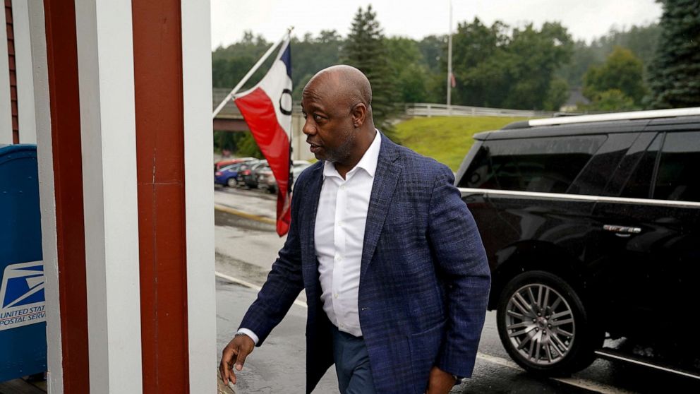 PHOTO: Republican presidential candidate Senator Tim Scott walks in the rain outside Robie's Country Store in Hooksett, New Hampshire, Aug. 25, 2023.