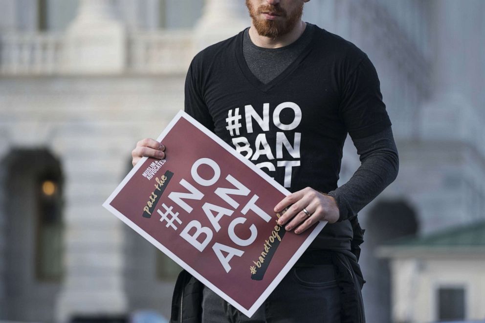 PHOTO: A man holds a sign showing their support of ending a travel ban on Muslim majority countries at a news conference outside of the Capitol Hill in Washington, Jan. 27, 2020.